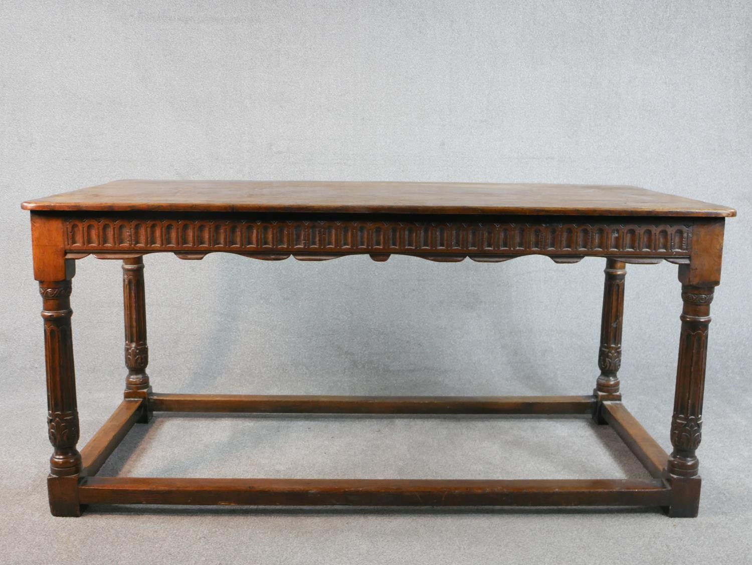An early 20th century oak refectory dining table, the rectangular top with rounded corners over a