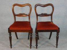 A pair of Victorian walnut kidney back dining chairs, the drop in seat upholstered in red velour, on