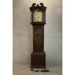 A 19th century carved oak longcase clock, the hood with a swan neck pediment and reeded columns, the