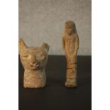 A carved sandstone Egyptian cat's head along with a shabti. L.16 W.4.5 D.3cm. (largest)