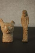 A carved sandstone Egyptian cat's head along with a shabti. L.16 W.4.5 D.3cm. (largest)