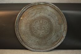 A very large brass Eastern engraved tray or table top with stylised floral and foliate design. D.