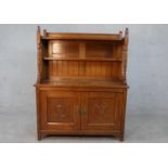 A late 19th century Arts and Crafts inspired sideboard with raised superstructure above panel