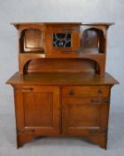 A late 19th century Arts and Crafts oak sideboard with raised superstructure above base fitted