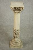 A late 20th century cast resin torchere, in the form of a Corinthian column, with a figural