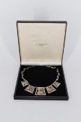 A boxed pierced Egyptian revival silver collar necklace with engraved figural and abstract design.