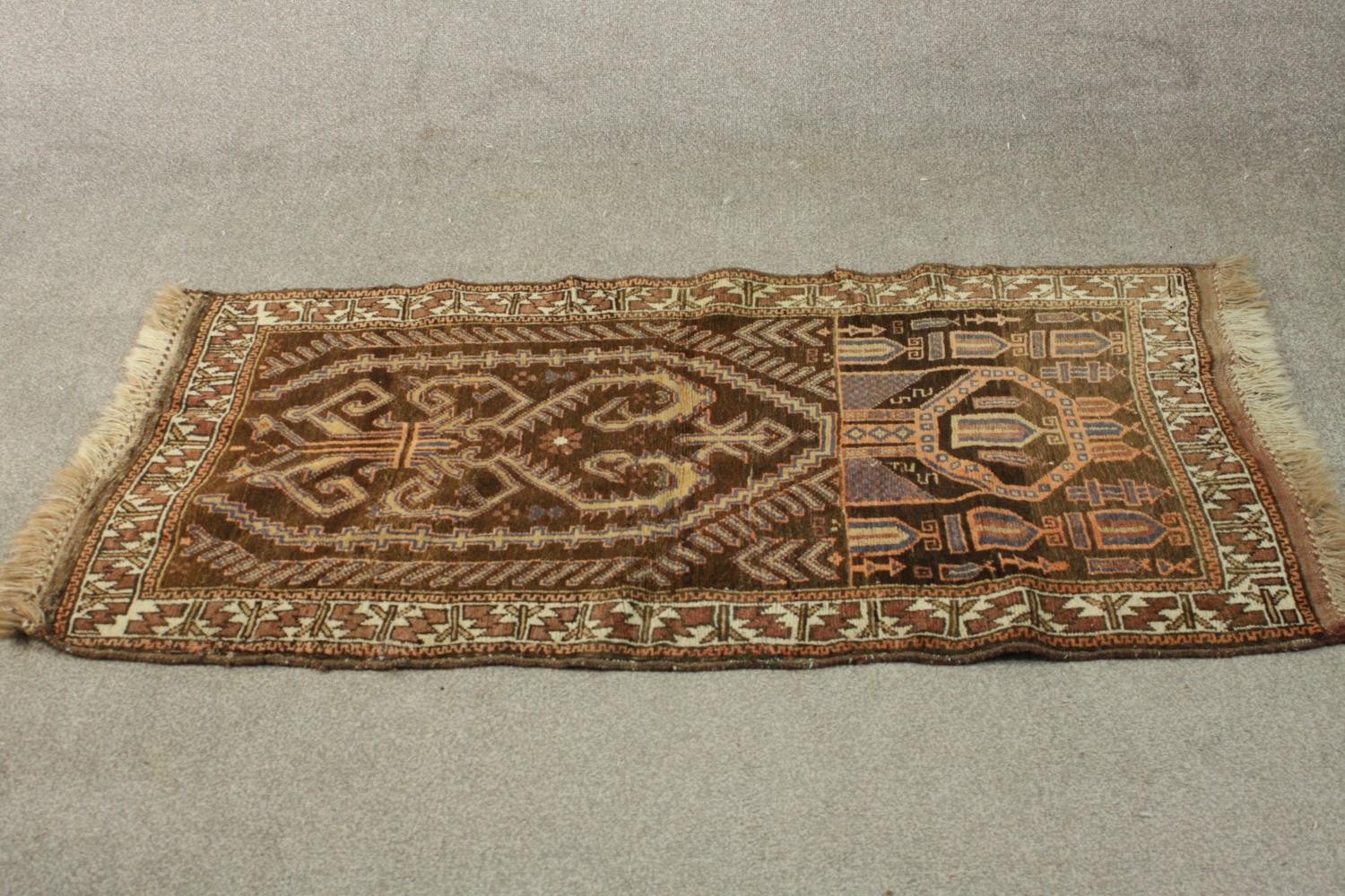 A hand made mocha ground Belouch rug. L.152 W.79cm.