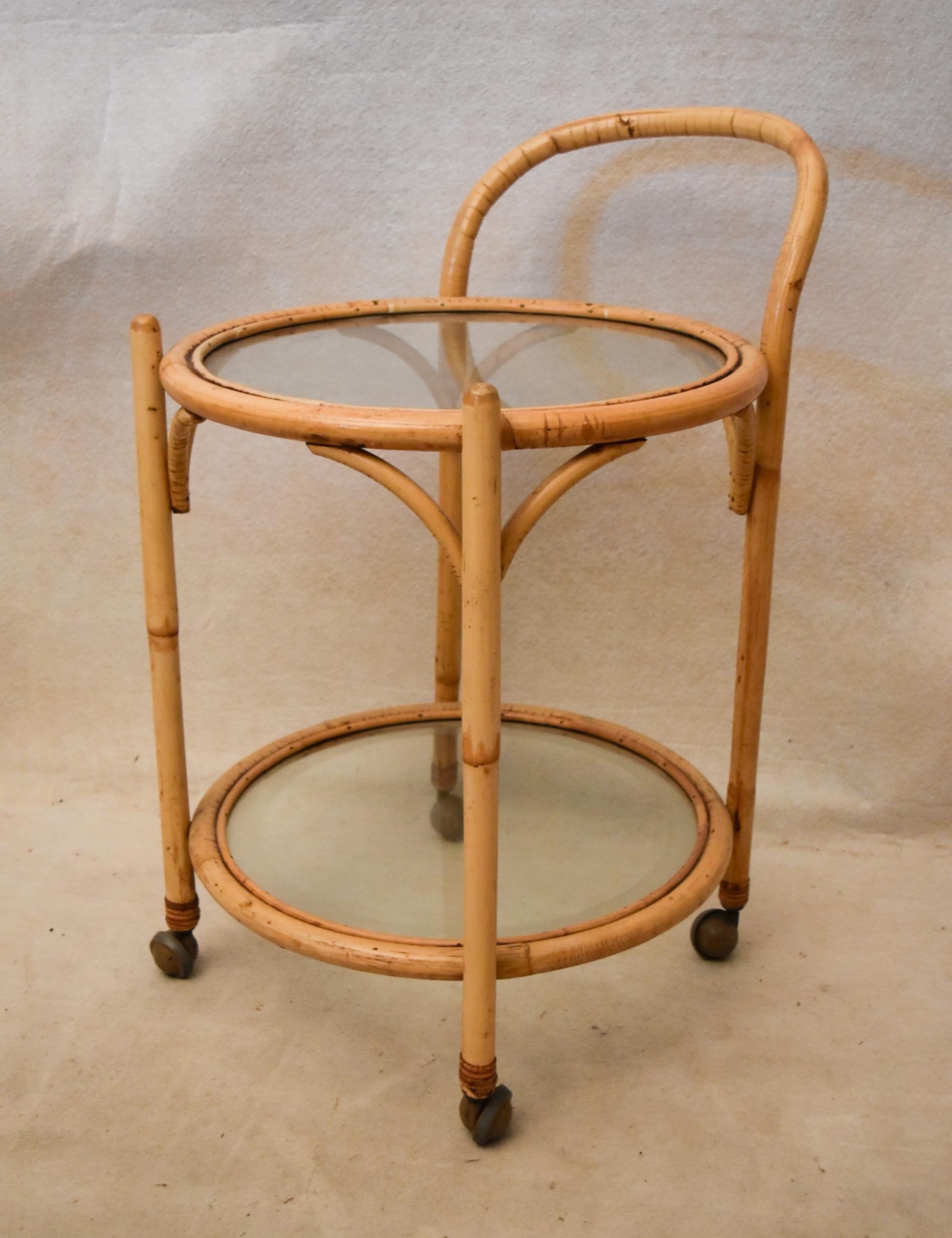 A mid 20th century bamboo drinks trolley, of circular form with two glass tiers. 50cm W x 50cm D x