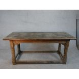 An 18th century oak planked top refectory dining table with cleated ends on turned stretched