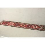 A hand made red ground Turkish Doshemolti runner. L.309 W.74cm.