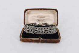 A boxed Art Deco marcasite and silver pierced geometric design bracelet with safety chain. Stamped