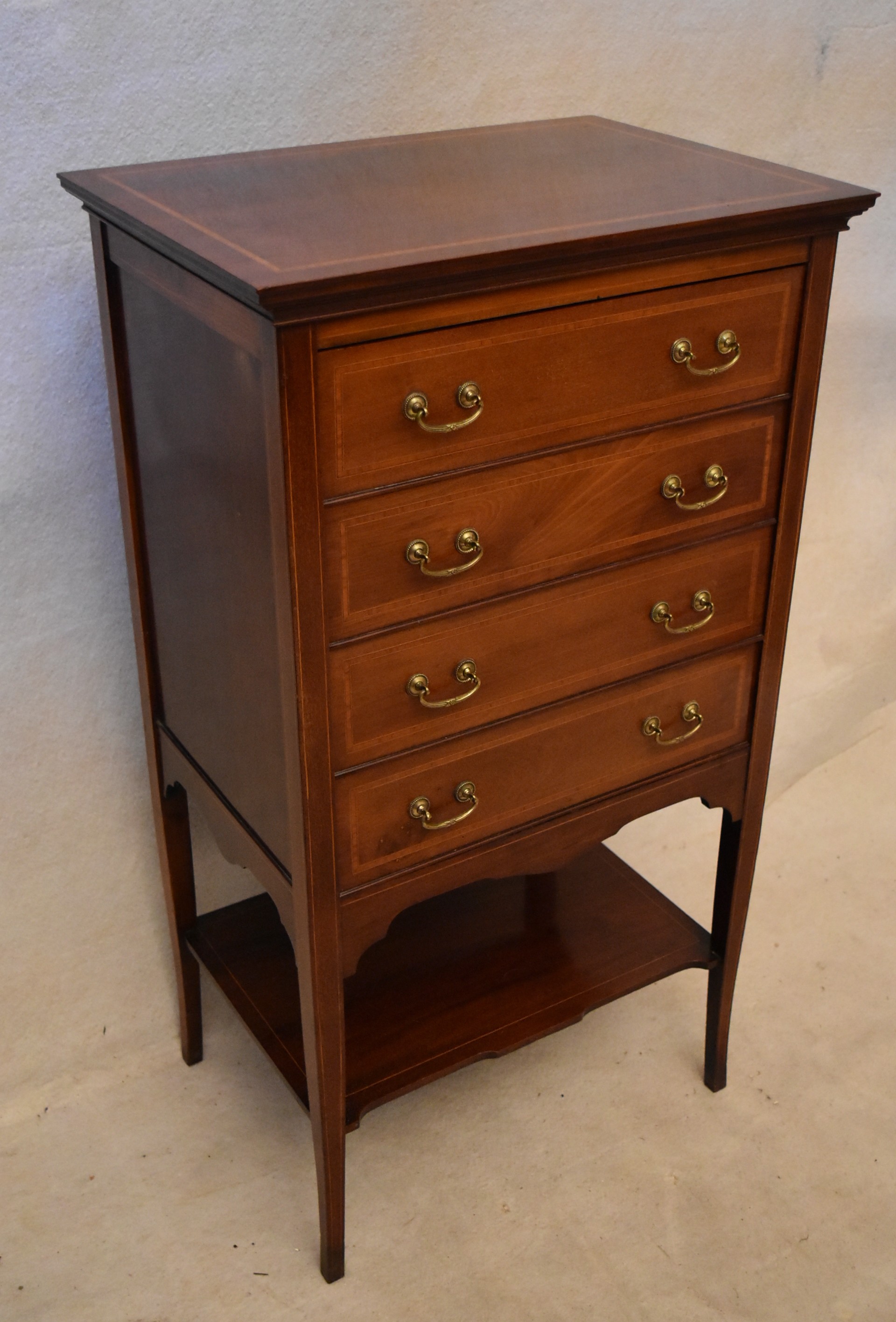 An Edwardian mahogany and inlaid music chest, the four long drawers with fall fronts over an