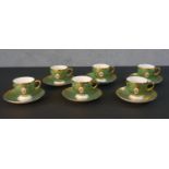 A six person Mintons hand painted green and gilded rose design coffee set. (one cup damaged) 12