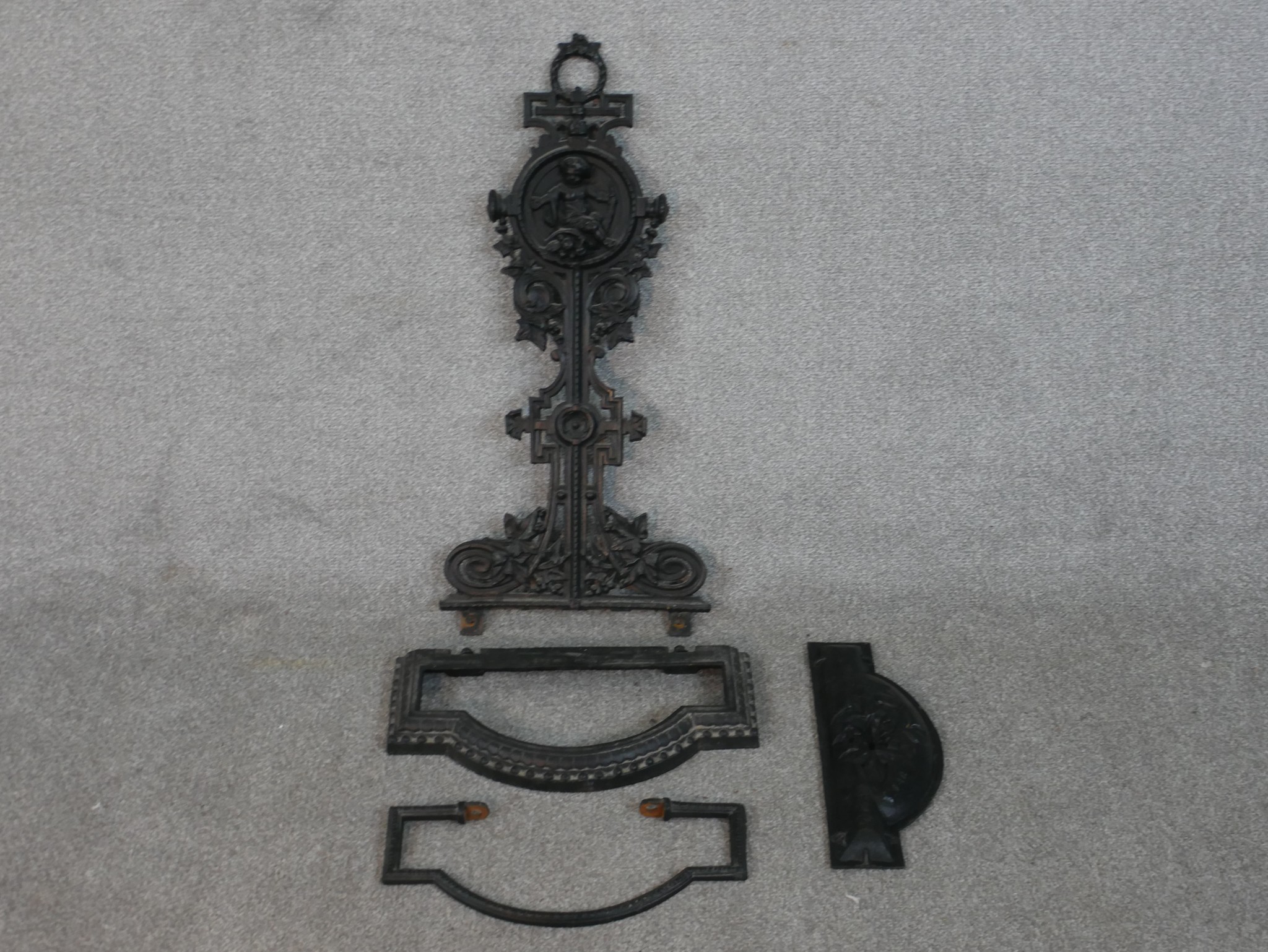 A Victorian black painted cast iron umbrella stand, in four parts, the back cast with a cherub