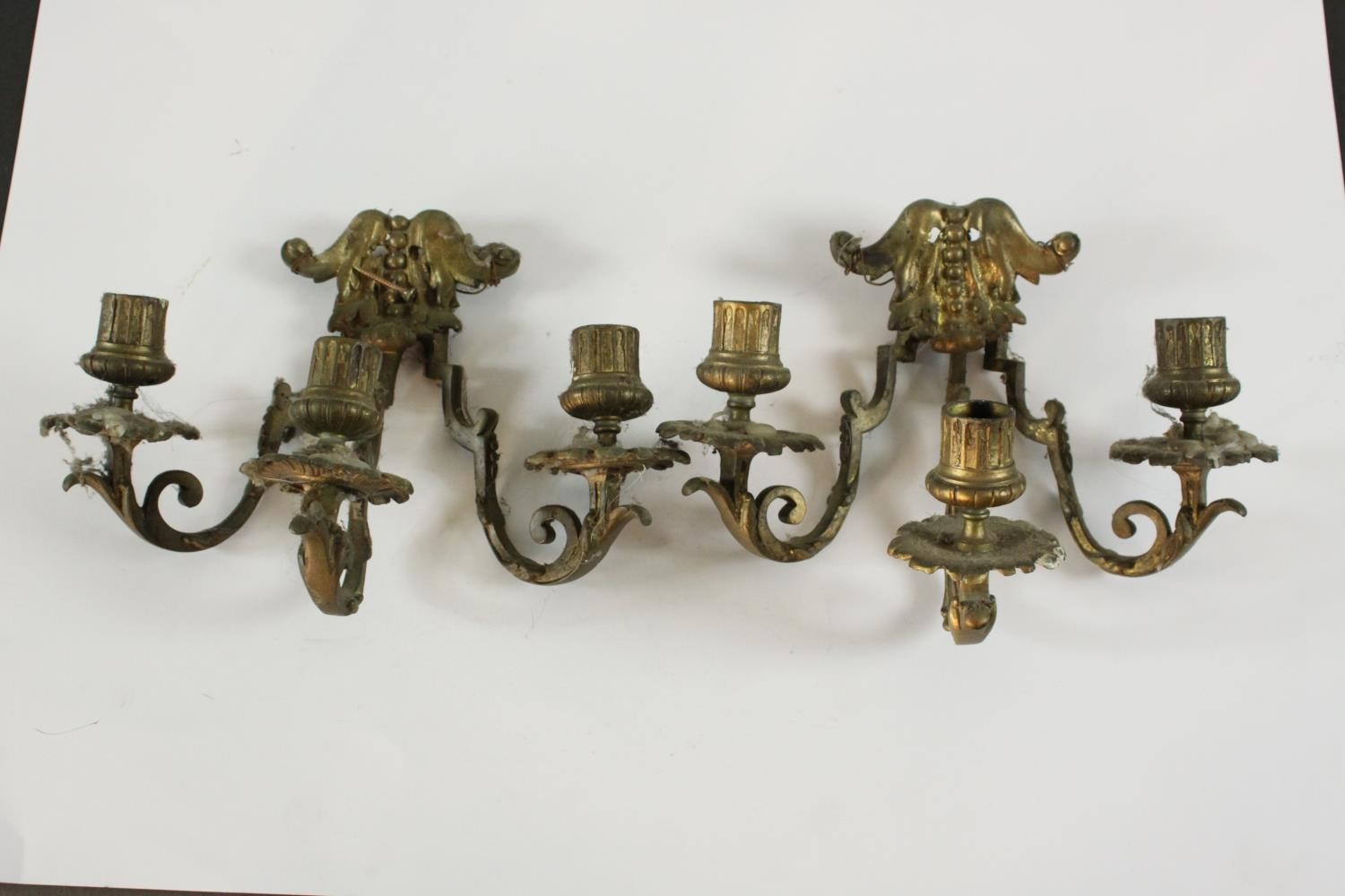 A pair of gilt brass three branch wall scones with stylised foliate design. H.20 W.26 D.18cm. (each)