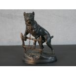 After Charles Valton, a spelter figure of a dog chained to a fence on an oval naturalistic base,