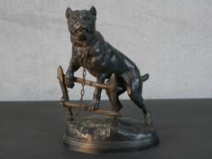 After Charles Valton, a spelter figure of a dog chained to a fence on an oval naturalistic base,