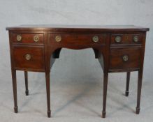 A George III mahogany kneehole bowfront sideboard, with a central drawer over a kneehole flanked