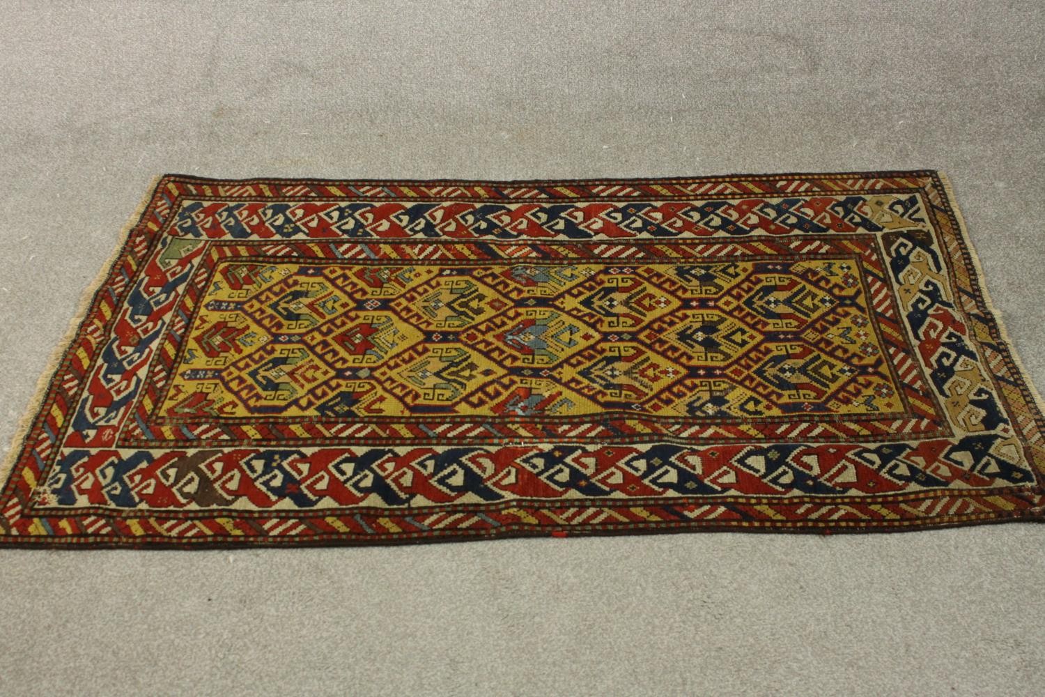 A gold ground hand made Kazak rug. L.151 W.88cm.