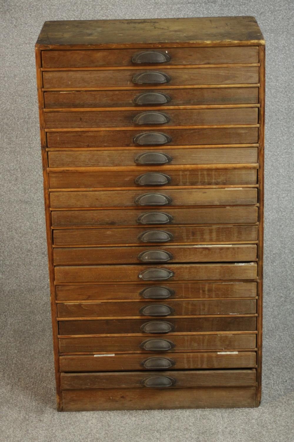 An early 20th century collector's or printer's chest of eighteen drawers with brass cup handles,