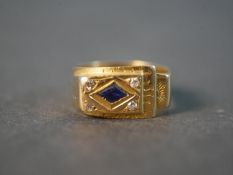 A yellow metal (tests as higher than 9ct) dress ring set with a diamond shaped sapphire and four