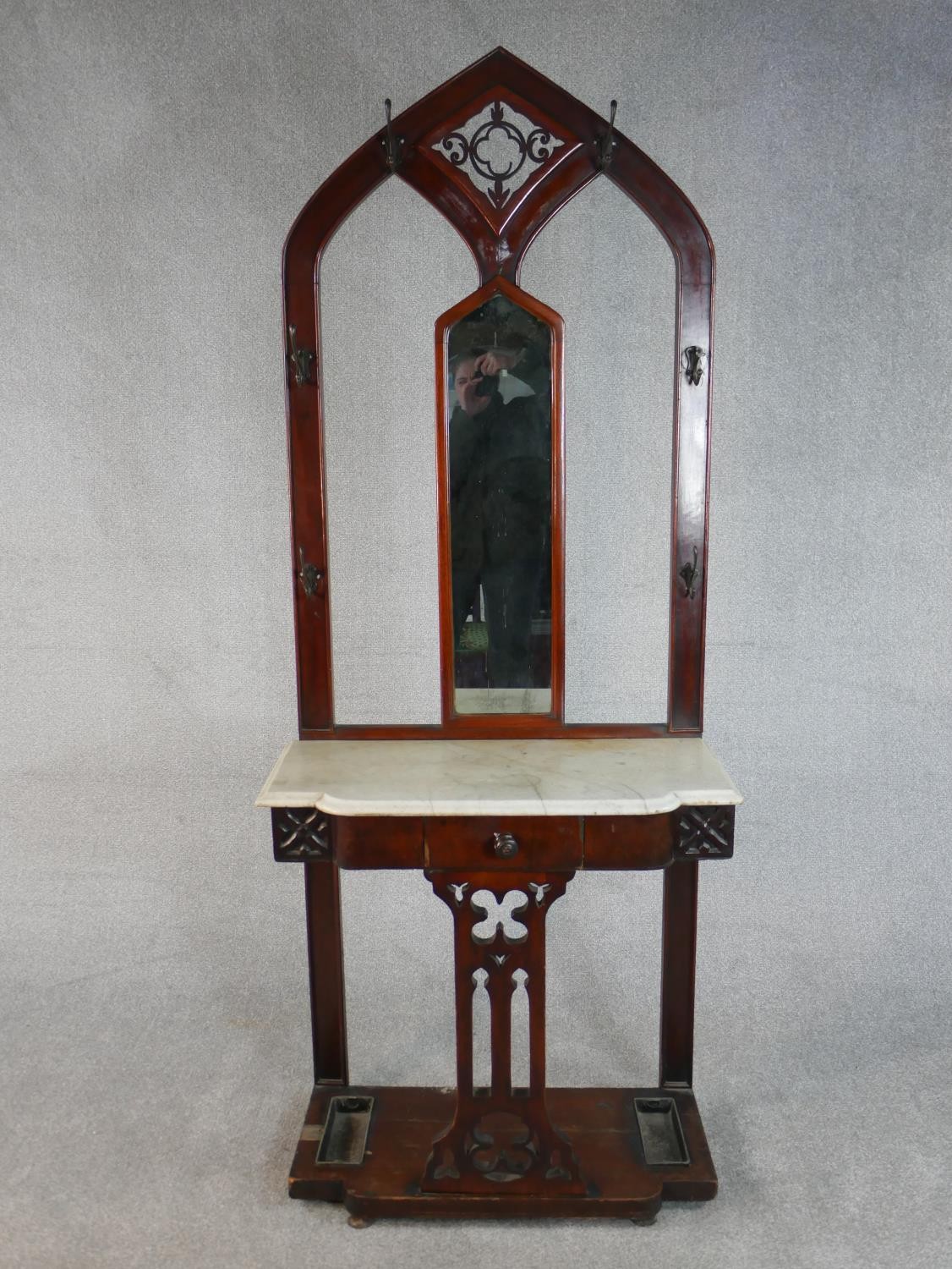 A Victorian Gothic Revival walnut hallstand, of arched form with a pierced panel centred by a