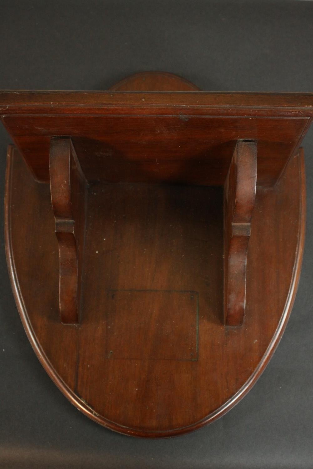 A Victorian walnut wall shelf on a shield shaped back. H.45 W.37 D.23cm.