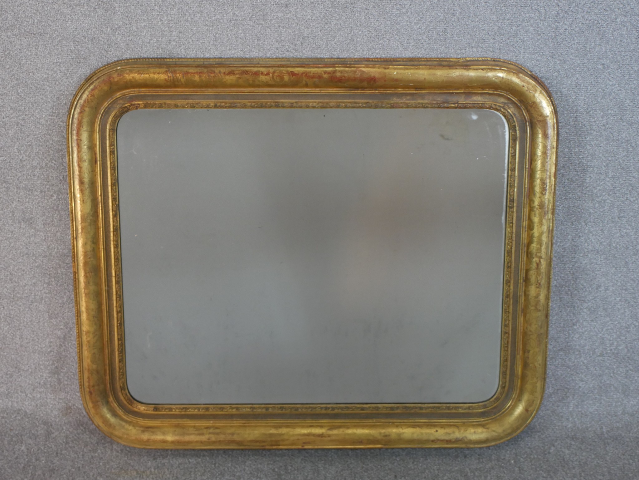 A 19th century gilt framed mirror, of rectangular form with rounded corners. H.77 W.93cm