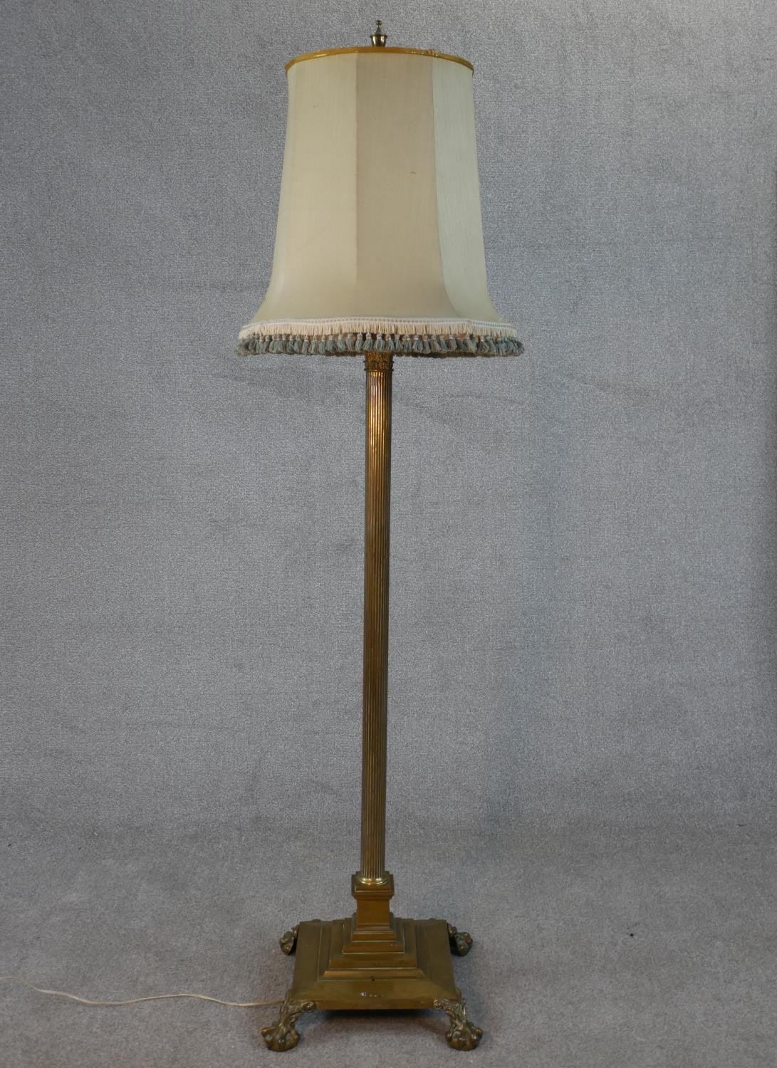 A Victorian brass fluted column design floor lamp with square base on four lion paw feet. H.170 W.38