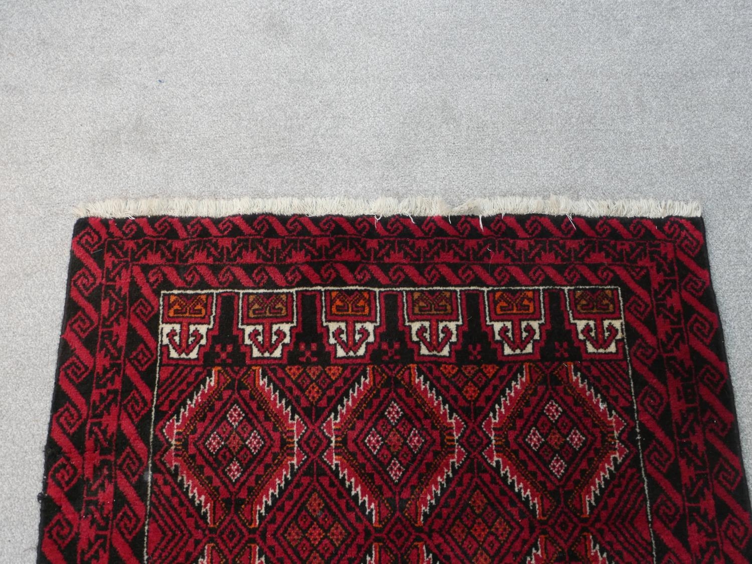 A Persian Meshed rug with repeating lozenge design on a burgundy ground within stylised borders. L. - Image 3 of 7