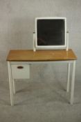 A vintage child's white painted dressing table, incorporating a square mirror on swing frame, the