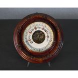 An early 20th century carved mahogany framed barometer with white enamel dial. Diam.29cm