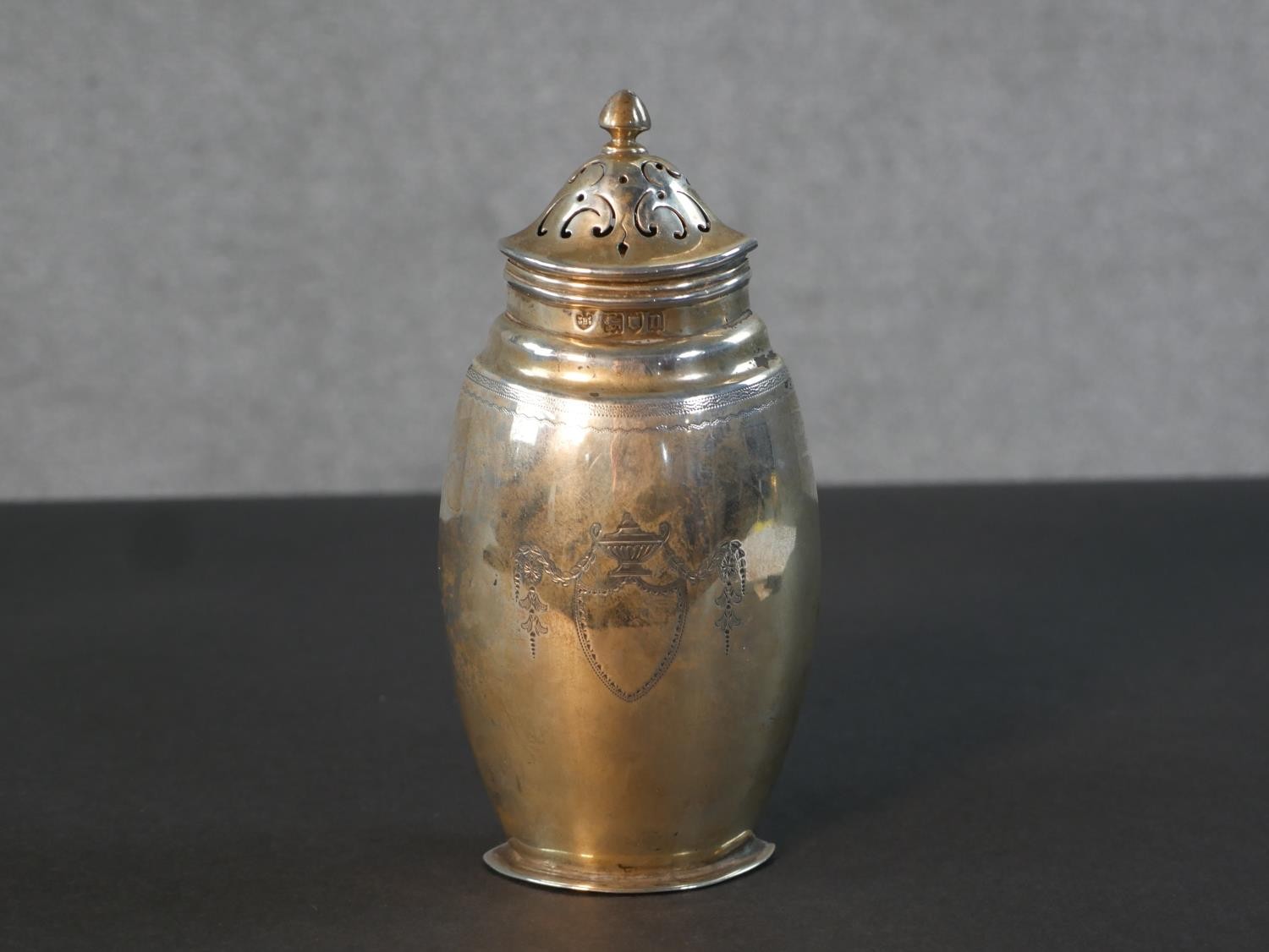 An Edwardian sterling silver urn form sugar sifter by Edward Barnard & Sons Ltd. Hallmarked: London,
