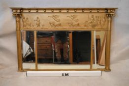 A Regency gilt overmantel mirror, the cornice adorned with balls, over a Classical figural panel,