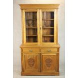 A Victorian style walnut bookcase, the two glazed doors enclosing shelves, over two short drawers