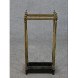 A late Victorian brass six section umbrella stand, with turned finials and a black painted cast iron