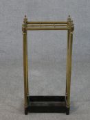 A late Victorian brass six section umbrella stand, with turned finials and a black painted cast iron