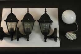 Three black enamel cast metal wall lanterns along with a chrome and opaque white glass ball wall