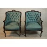 A pair of Edwardian walnut tub armchairs, upholstered in buttoned blue damask, with scrolling arms