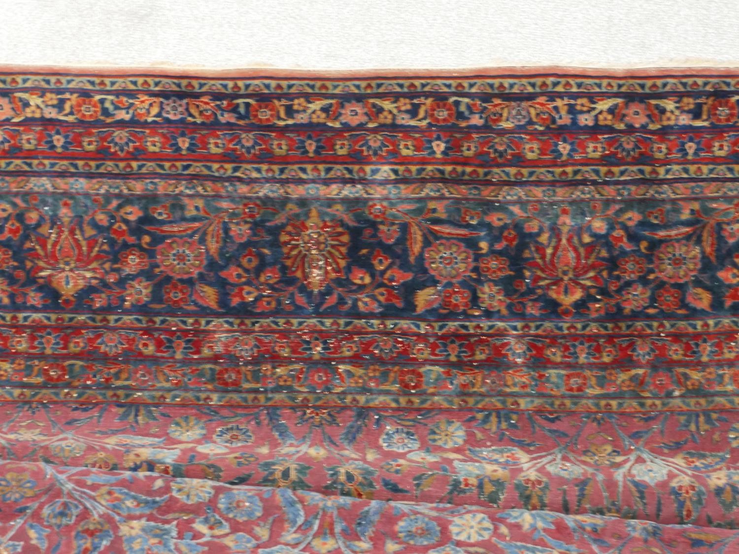 A fine hand woven Persian Sarouk carpet with scrolling foliate decoration across the burgundy - Image 3 of 7