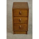 A 1940s Heal's style oak utility bedside chest of three drawers on a plinth base. H.85 W.56 D.48cm.