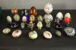 A collection of twenty six decorative eggs, including three Halcyon Days enamel egg boxes, a musical