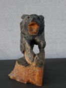 A black forest carved and painted bear with salmon. H.27 W.25cm