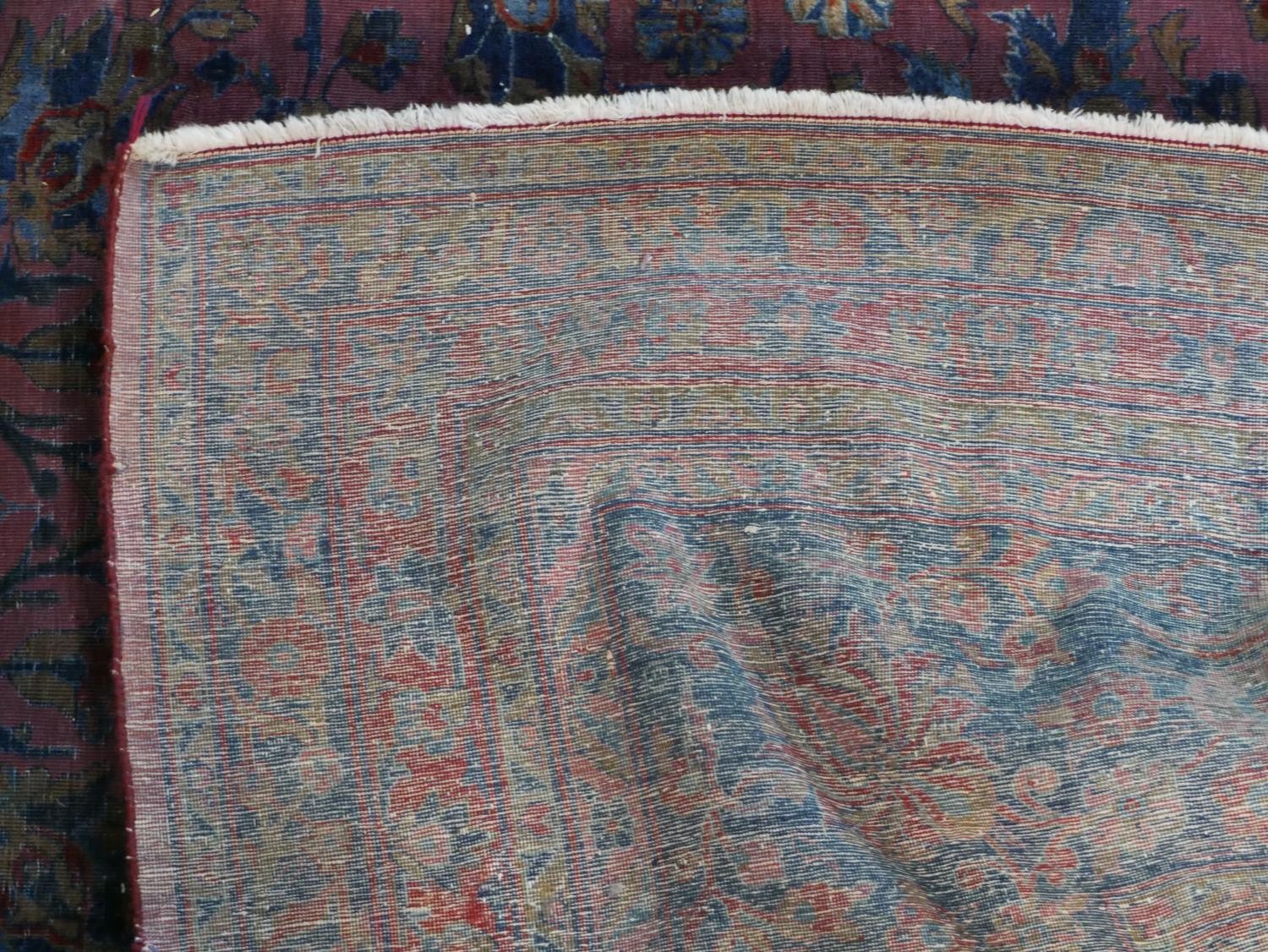 A fine hand woven Persian Sarouk carpet with scrolling foliate decoration across the burgundy - Image 7 of 7