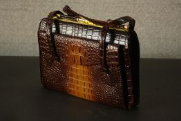 A 20th century crocodile skin handbag with brass hardware. H.23 W.32cm.