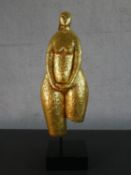 A gold painted terracotta figure of a nude woman mounted on a display stand. H.60 W.19 D.13cm