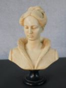 A reconstituted marble bust of a lady on a black resin pedestal base. H.32CM
