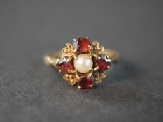 A 9 carat yellow gold garnet and cultured pearl heart design dress ring, set with a round cultured