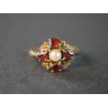 A 9 carat yellow gold garnet and cultured pearl heart design dress ring, set with a round cultured