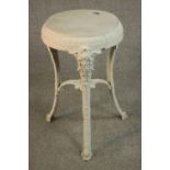 A Victorian white painted cast iron pub table, circular, raised on three curved legs with mask